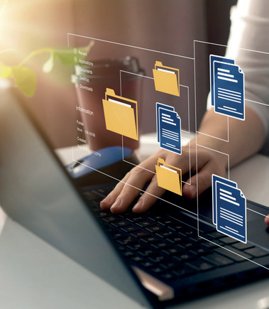 Eine Hand bedient einen Laptop mit digitalen Dokumenten‑Symbolen